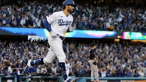 The Dodgers' Chris Taylor jogs around the bases after he hit a two-run home run off of  Braves starting pitcher Max Fried, right, during the second inning in Game 5 at the National League Championship Series at Dodger Stadium on Thursday. (Curtis Compton / curtis.compton@ajc.com)