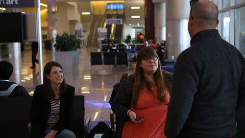 Attorneys Sydney Strickland and Leigh Ann Webster talk to traveler Matthew Awalt at the International terminal at Hartsfield-Jackson International Airport on Monday. (Photo by Henry Taylor/henry.taylor@ajc.com)