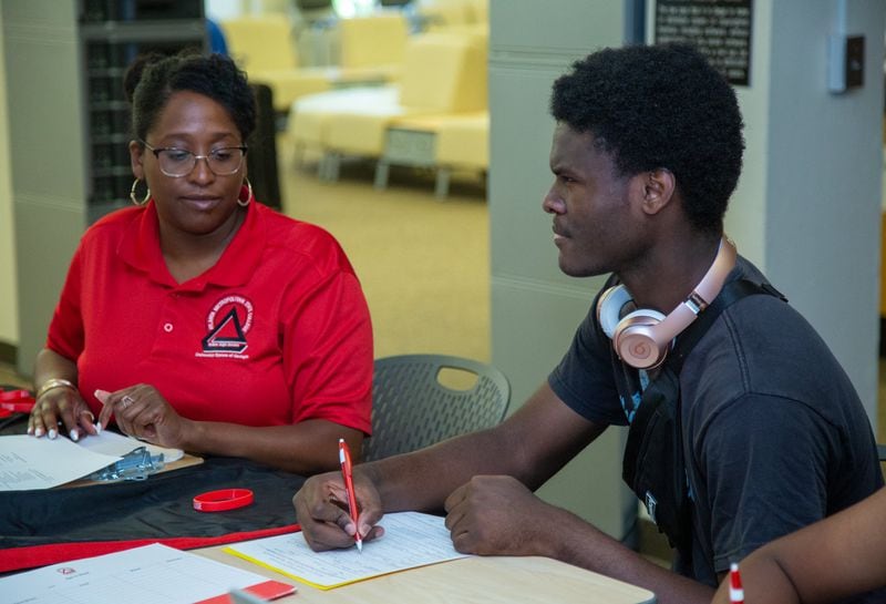 Shari Speller (left) helps Dorien Head fill out an application to Atlanta Metropolitan College at a college and career expo hosted at Fredrick Douglass High School, in Atlanta, on Wednesday, July 24, 2019, as part of a program offering help to recent Atlanta high school graduates. (Photo by Phil Skinner)