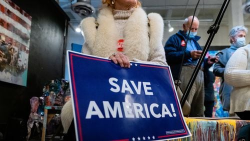 Teresa Gipson, of Atlanta, holds a 'Save America' sign during a stop on the 'Save America’ statewide bus tour organized by The Club For Growth, on Wednesday, December 16, 2020, in Atlanta. (Elijah Nouvelage for The Atlanta Journal-Constitution)