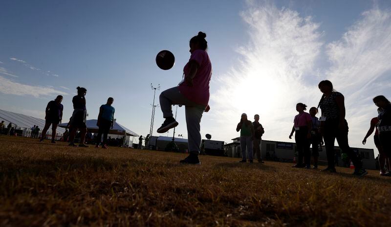 File - In this July 9, 2019, photo, immigrants play soccer at the U.S. government's newest holding center for migrant children in Carrizo Springs, Texas. The Biden administration plans to partially end the 27-year-old court supervision of how the federal government cares for child migrants, shortly after producing its own list of safeguards against mistreatment. (AP Photo/Eric Gay, File)