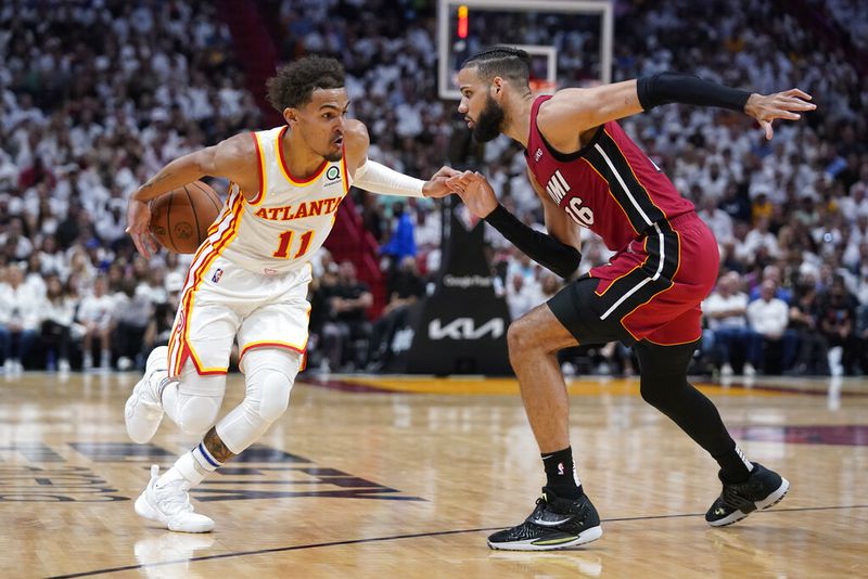 Atlanta Hawks guard Trae Young (11) loses control of the ball as he drives to the basket against Miami Heat forward Caleb Martin (16) during the second half of Game 5 of an NBA basketball first-round playoff series, Tuesday, April 26, 2022, in Miami. (AP Photo/Wilfredo Lee)