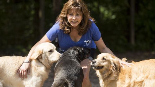 Susie Aga, founder of Atlanta Dog Trainer, a "premier dog training and behavior modification center in the Southeast," with dogs at her facility.