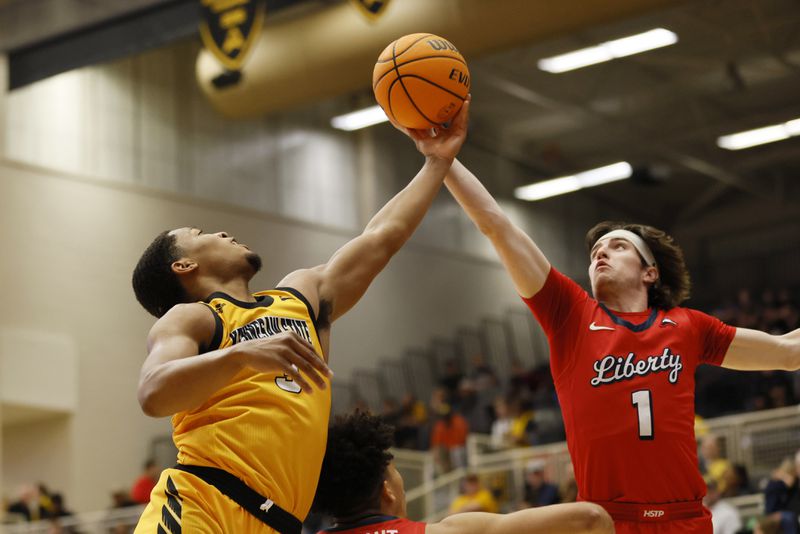 Kennesaw State guard Chris Youngblood (left) reaches for a rebound with Liberty Flames guard Darius McGhee during the first at the Kennesaw State Convention Center on Thursday, Feb 16, 2023.  Miguel Martinez / miguel.martinezjimenez@ajc.com