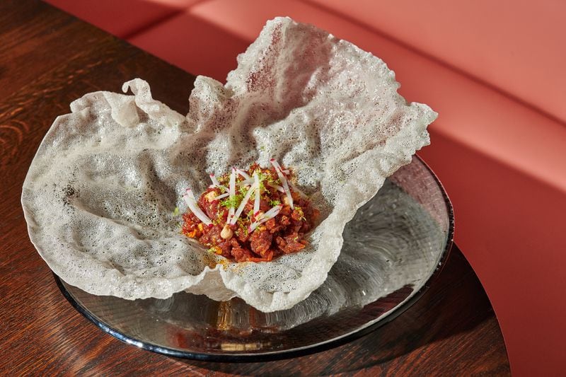 The wagyu beef tartare at Atrium is served on a rice puff and dressed with a savory chile crunch. Courtesy of Angie Webb