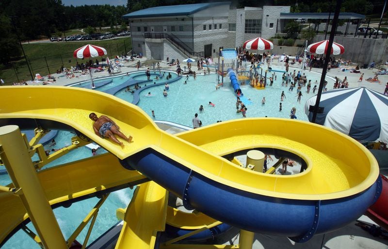  A visitor goes down the open water slide at the outdoor leisure pool at Mountain Park Aquatic Center in Stone Mountain. (File photo)