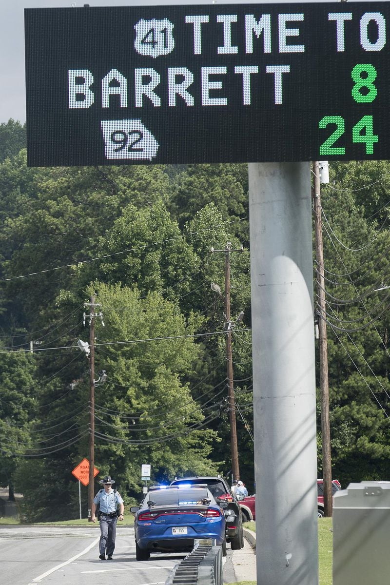 6/19/2019 — Marietta, Georgia — A Georgia State Trooper issues a citation to a driver during a Marietta Police Department multi-agency distracted driving enforcement operation in Marietta, Wednesday, June 19, 2019. The operation, which involved three under-cover Marietta Police officers dressed as construction workers, took place at the intersection of US 41 and Roswell Road. When the officers saw a distracted driving violation, in addition to others, they radioed ahead and one of the forty officers involved in the operation issued a citation to the driver. (Alyssa Pointer/alyssa.pointer@ajc.com)