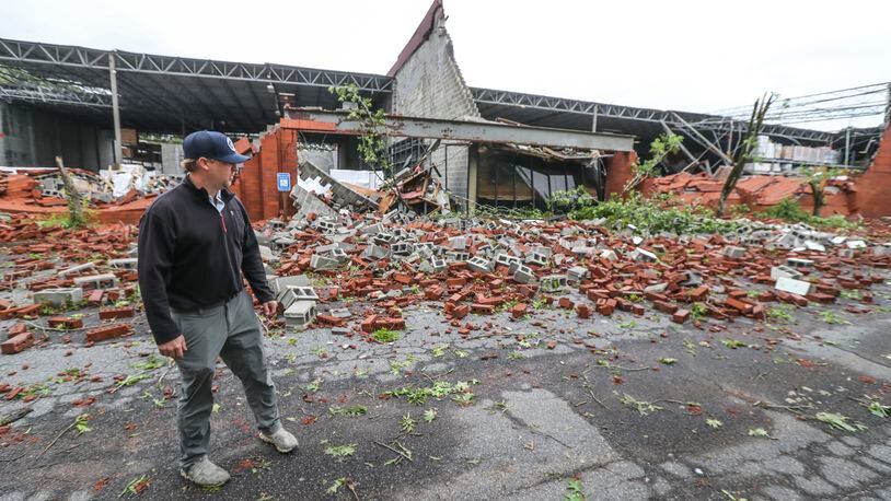 Dru Ghegan surveys the damage to his Fulton County business Tuesday after a severe storm rolled through the area.