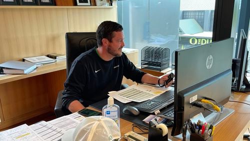 Oregon coach Dan Lanning, just seven months on the job since leaving Georgia as defensive coordinator, scrolls through some practice video in his office in the third floor of the Ducks' Hatfield-Dowlin football operations building in Eugene, Ore., on Aug. 8, 2022. (Photo by Chip Towers/ctowers@ajc.com)