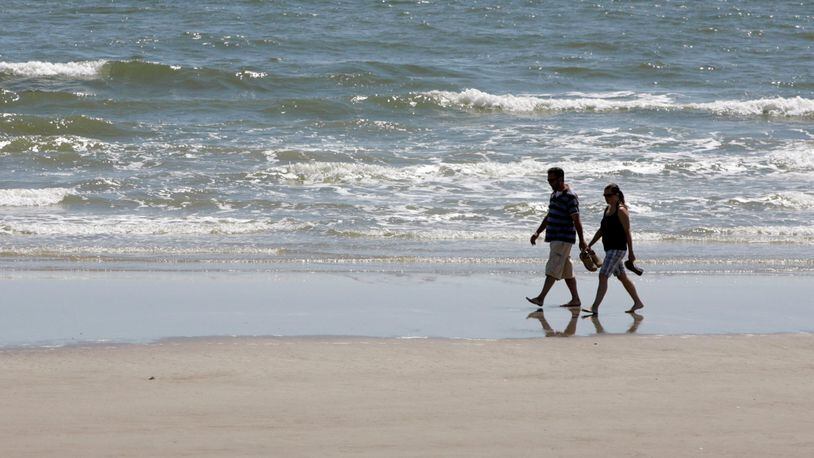 A couple walks along the Galveston, Texas, beach during low tide Friday, Oct. 3, 2008.