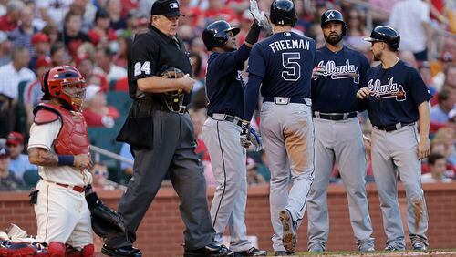 Braves’ Freddie Freeman (5) celebrates with teammates after hitting a three-run home run as home plate umpire Jerry Layne (24) and St. Louis Cardinals catcher Yadier Molina look on in the third inning Saturday, Aug. 6, 2016, in St. Louis. (Tom Gannam/AP)