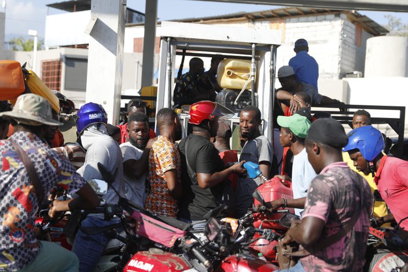 People crowd around a fuel pump at a gas station in Port-au-Prince, Haiti, Saturday, April 6, 2024. (AP Photo/Odelyn Joseph)