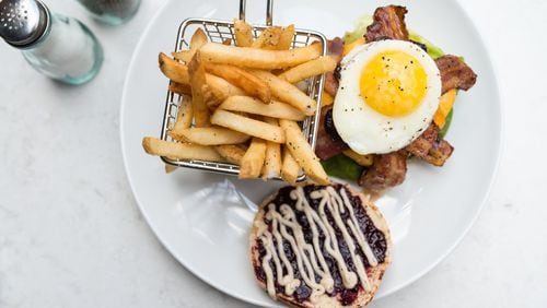 Todd English Tavern Southern Burger with beef brisket and short rib patty, bacon, fried egg, wild berry jam, cheddar, butter lettuce, tomatoes, onions, and spicy mayo. Photo credit- Mia Yakel.