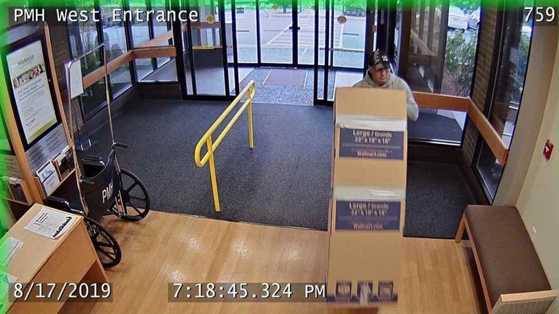 Surveillance cameras caught a man wheeling an ATM out of an Oregon hospital. The man used a cardboard box to cover the machine.