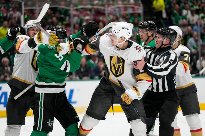 NHL linesman Trent Knorr (74) and players try to intervene as Dallas Stars defenseman Nils Lundkvist (5) and Vegas Golden Knights center Brett Howden (21) get tangled up during the second period in Game 2 of an NHL hockey Stanley Cup first-round playoff series in Dallas, Wednesday, April 24, 2024. (AP Photo/Tony Gutierrez)