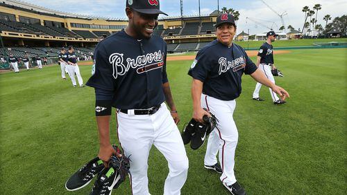Braves pitchers Julio Teheran (L) and new 40-something addition Bartolo Colon share a laugh as they take the field for Wednesday's workout at Lake Buena Vista, Fla. ( Curtis Compton/ccompton@ajc.com