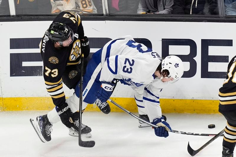 Boston Bruins' Charlie McAvoy (73) and Toronto Maple Leafs' Matthew Knies (23) battle for the puck during the first period of Game 7 of an NHL hockey Stanley Cup first-round playoff series, Saturday, May 4, 2024, in Boston. (AP Photo/Michael Dwyer)