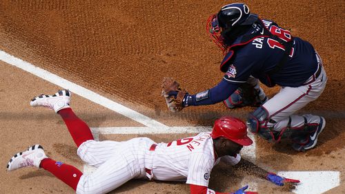 Andrew McCutchen scores past Braves catcher Travis d'Arnaud during the first inning of Thursday's Phillies-Braves game in Philadelphia.