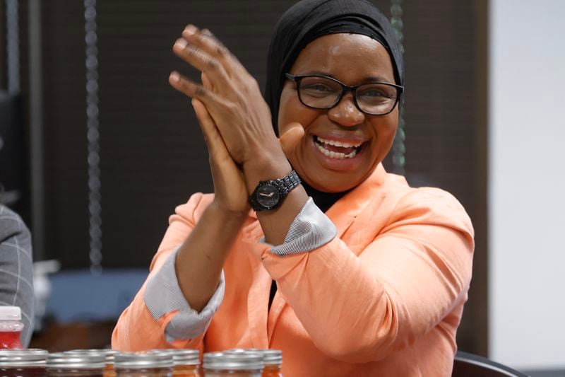 Small business owner Nimota Salami from Nigeria claps after speaking during an event celebrating the two-year anniversary of the International Rescue Committee's Community Navigator Pilot Program at IRC headquarters on Friday, June 23, 2023. The federally funded program was created to assist immigrants and refugees with tools to grow their small businesses. (Natrice Miller/natrice.miller@ajc.com)