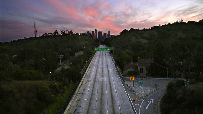 In this April 26, 2020, photo, empty lanes of the 110 Arroyo Seco Parkway that leads to downtown Los Angeles is seen during the coronavirus outbreak. The world cut its daily carbon dioxide emissions by 17% at the peak of the pandemic shutdown, a new study found. But with life and heat-trapping gas levels inching back toward normal, the brief pollution break will likely be “a drop in the ocean.” (AP Photo/Mark J. Terrill)