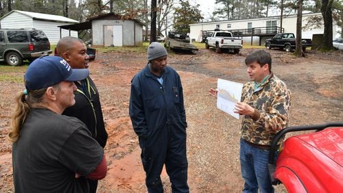 Fletcher Sams (right), executive director at Altamaha Riverkeeper, shows a map of Georgia Power’s ash pond and explains potential problems as (from left) Don Lance, John David Johnson and Huriah Stewart look on. Sams collected water samples at Johnson’s home near Georgia Power’s coal-fired power plant in Juliette. Johnson says he hasn’t drunk the water in Juliette for years. HYOSUB SHIN / HYOSUB.SHIN@AJC.COM