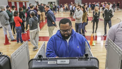 Ken Hammond votes and the long line wraps around the gym behind him on Tuesday, Nov. 8, 2016, at Henry W. Grady High School in Atlanta. JOHN SPINK /JSPINK@AJC.COM