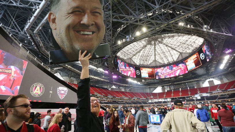 Founders Club member Tim Tewell from East Cobb shows his support for Atlanta United by holding a 'Tata' Martino banner from the 100 concourse in Mercedes-Benz Stadium on March 11, 2018 in Atlanta Ga.