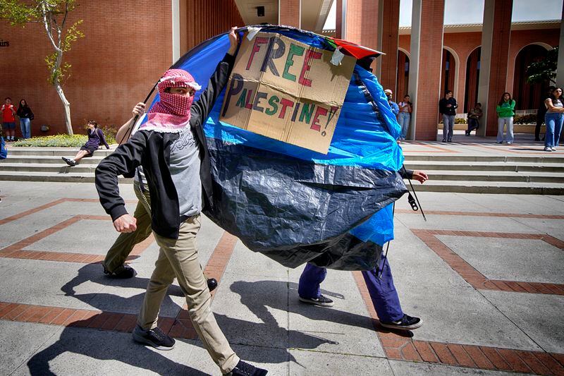 FILE - University of Southern California protesters carry a tent around Alumni Park on the University of Southern California to keep security from removing it during a pro-Palestinian occupation, Wednesday, April 24, 2024, in Los Angeles. (AP Photo/Richard Vogel, File)