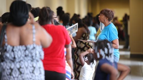 Parents and children line up to receive supplies and health screenings at World Changers Church International. CONTRIBUTED