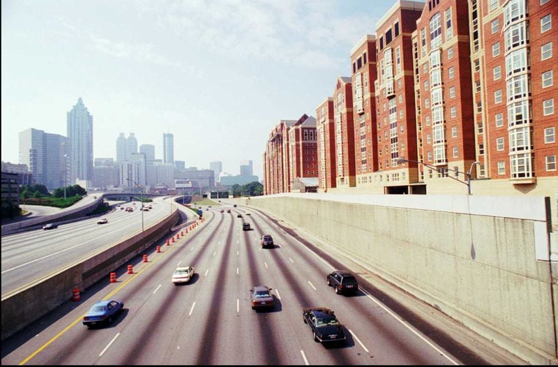 Traffic flows along the downtown connector between a portion of the Olympic Village on the right and the city skyline in 1995. The village is still being used as university dormitories.