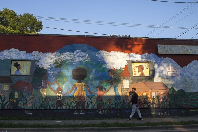 A man walks past a mural on St. Jose Street SW. Atlanta’s Ashview Heights neighborhood is next door to the historically black colleges of Atlanta University Center. Residents moved to the historically black area because they have personal ties to it, or see its potential. ALYSSA POINTER / ALYSSA.POINTER@AJC.COM