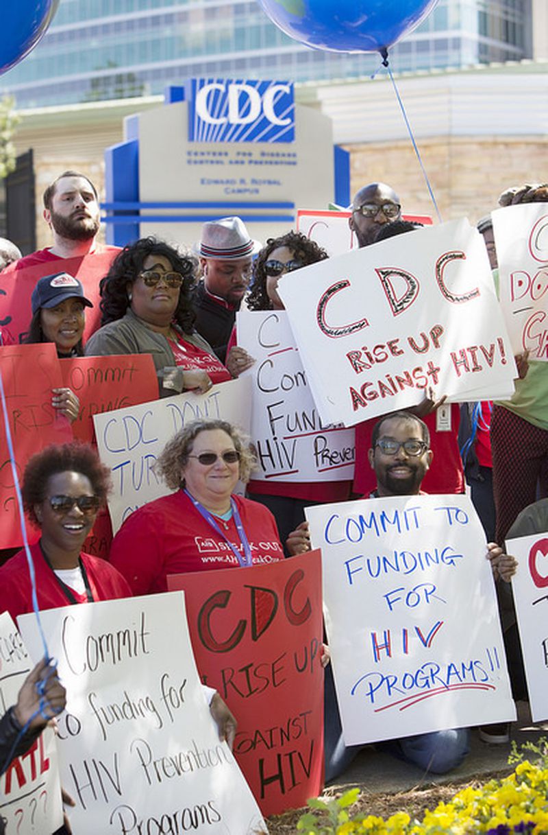 Protesters converged on the Centers for Disease Control and Prevention headquarters carrying placards Friday after learning the agency had denied funding to AID Atlanta. CONTRIBUTED
