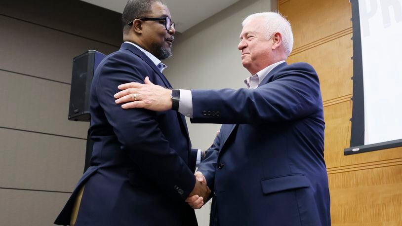 AJC editor-in-chief Leroy Chapman Jr. left, shakes hands with outgoing AJC editor Kevin Riley during the AJC Town Hall meeting at Cox Headquarters on Thursday, March 23, 2023, in Atlanta. (Miguel Martinez for the Atlanta Journal-Constitution)