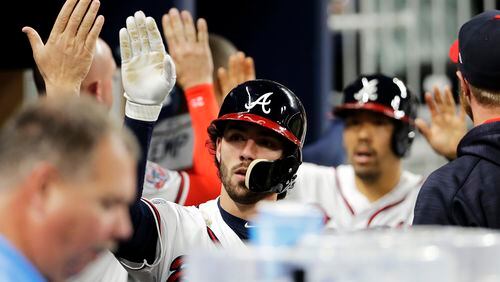 Braves’ Dansby Swanson, left, and Kurt Suzuki high-five teammates after scoring off a single by Ender Inciarte in the fourth inning. (AP Photo/David Goldman)