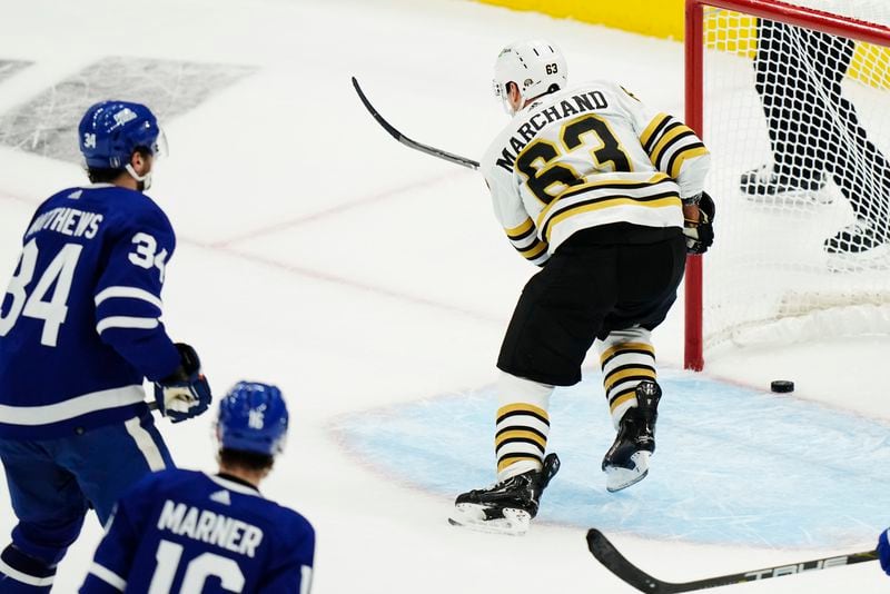 Boston Bruins' Brad Marchand (63) scores an empty-net goal as Toronto Maple Leafs' Auston Matthews (34) and Mitch Marner (16) watch during the third period in Game 3 of an NHL hockey Stanley Cup first-round playoff series in Toronto on Wednesday, April 24, 2024. (Frank Gunn/The Canadian Press via AP)