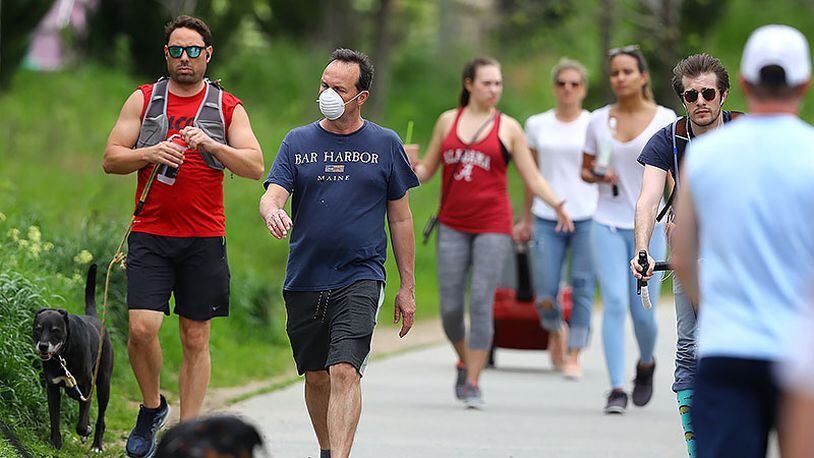 A man wears a mask while walking with the crowd on the Atlanta BeltLine trail on Sunday. Curtis Compton ccompton@ajc.com