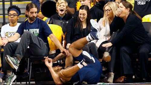 Georgia Tech’s Tadric Jackson (1) falls into the first row of the audience after colliding with Virginia Commonwealth’s Mo Alie-Cox during the first half of an NCAA college basketball game in Richmond, Va., Wednesday, Dec. 7, 2016. (Mark Gormus/Richmond Times-Dispatch via AP)