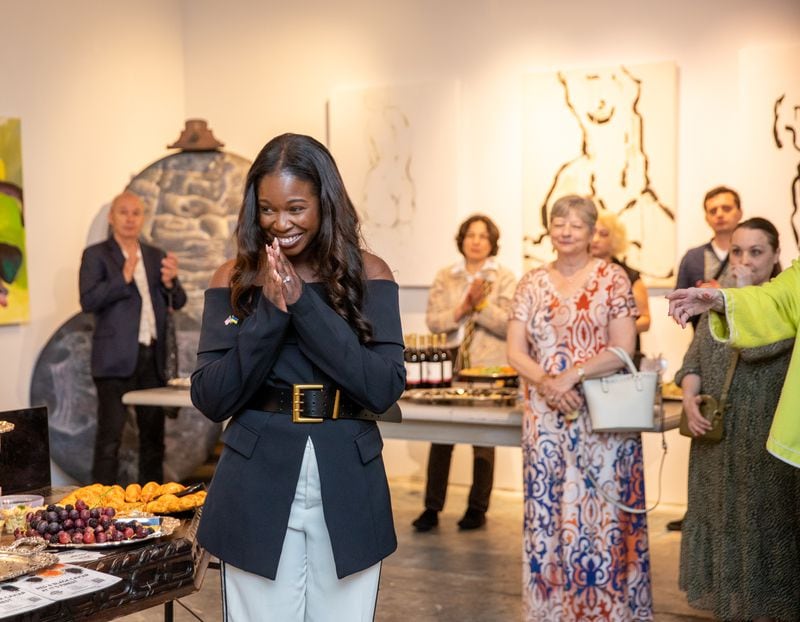 Buckhead Art & Company new owner Karimah McFarlane thanks supporters and addresses the crowd at the opening of a month-long show featuring artists from Ukraine. (Jenni Girtman for The Atlanta Journal-Constitution)