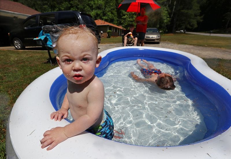 Bradley Murchison, 1, and his brother George, 6, try to beat the heat while visiting their great-grandmother Joyce Webb for the Memorial Day 2019 holiday weekend in College Park.