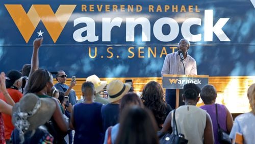 U.S. Raphael Warnock greets supporters during a campaign stop at the Cobb County Civic Center on Wednesday, August 31, 2022, in Marietta Shown in the background is his campaign bus. (Jason Getz / Jason.Getz@ajc.com)