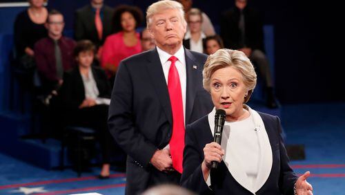 Democratic presidential nominee Hillary Clinton, right, speaks as Republican presidential nominee Donald Trump listens during the second presidential debate at Washington University in St. Louis on Oct. 9. 2016.