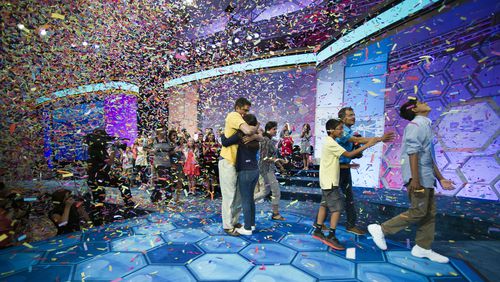 Scripps National Spelling Bee co-champion Vanya Shivashankar, 13, center, of Olathe, Kan., hugs her father Merl Shivashankar while co-champion Gokul Venkatachalam, 14, right, of St. Louis, celebrates as his family reaches out to him in this 2015 file photo.
