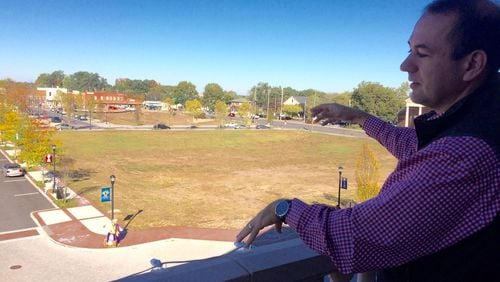 Alpharetta Mayor David Belle Isle stands on the balcony of the new City Hall and points out the new downtown he envisions. Photo by BILL TORPY