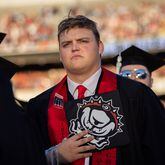 James Noah Sanders holds his Bulldogs graduation cap to his heart during the national anthem at Sanford Stadium during the University of Georgia spring commencement in Athens on Friday, May 10, 2024. (Arvin Temkar / AJC)