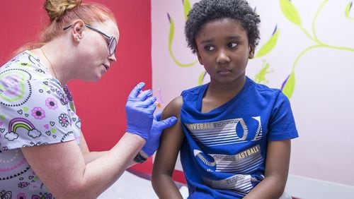 In this file photo, Logan Edwards, 7, of Conyers, receives an Influenza Vaccine shot from LPN Katie Childress during his visit to Conyers Pediatrics in Conyers. (Alyssa Pointer/Atlanta Journal Constitution)