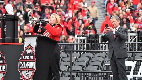 January 15, 2022 Athens - Governor Brian Kemp holds his iPhone as a lone trumpet player performs during the celebration of Georgia’s College Football Playoff national championship at Sanford Stadium in Athens on Saturday, January 15, 2022. Georgia captured the national championship, its first since the 1980 season, with a 33-18 victory over Alabama at Lucas Oil Stadium in Indianapolis. (Hyosub Shin / Hyosub.Shin@ajc.com)