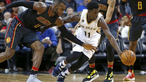 New Orleans Pelicans guard Jrue Holiday (11) and Atlanta Hawks forward Paul Millsap (4) chase a loose ball in the second half of an NBA basketball game in New Orleans, Thursday, Jan. 5, 2017. The Hawks won 99-94. (AP Photo/Gerald Herbert)