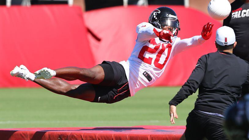 Falcons cornerback Kendall Sheffield stretches out to block a soccer ball while running an agility drill during the third practice of training camp Wednesday, July 24, 2019, in Flowery Branch.