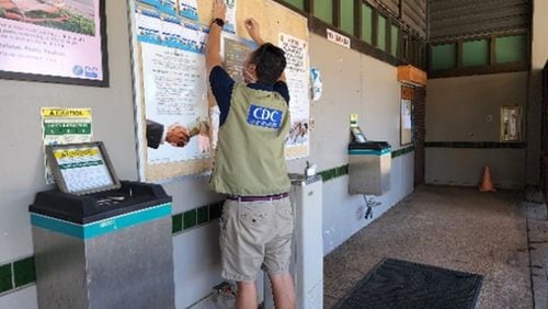 EIS officer Daniel Nguyen hangs up a recruitment flyer for the follow-up survey investigating ongoing health effects related to the jet fuel contamination of the Joint Base Pearl Harbor Hickam water system at a local community center in September 2022. PROVIDED BY CDC