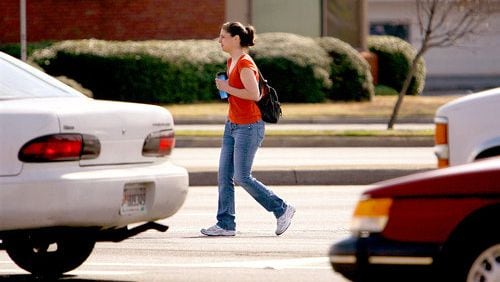 Police officer Cynthia Hollis, walking in plainclothes, makes her way across the crosswalk at Jimmy Carter Boulevard and S. Norcross Tucker Road. She served as the pedestrian that drivers should have stopped for.